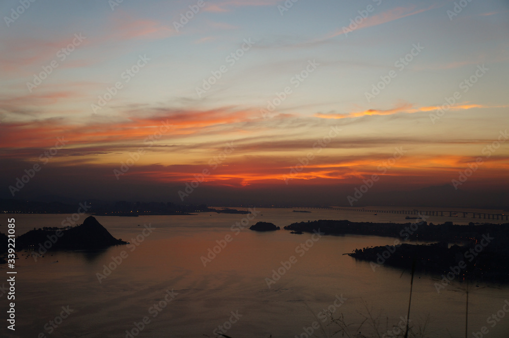 Naklejka premium Sunset at Niteroi and Rio de Janeiro cities, Brazil. View of tourist spots in the cities, such as Guanabara Bay, Sugarloaf Cable Car, Christ the Redeemer statue