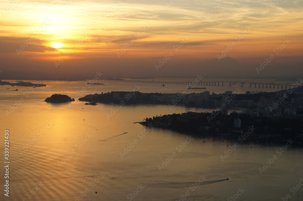 Sunset at Niteroi and Rio de Janeiro cities, Brazil. View of tourist spots in the cities, such as Guanabara Bay, Sugarloaf Cable Car, Christ the Redeemer statue