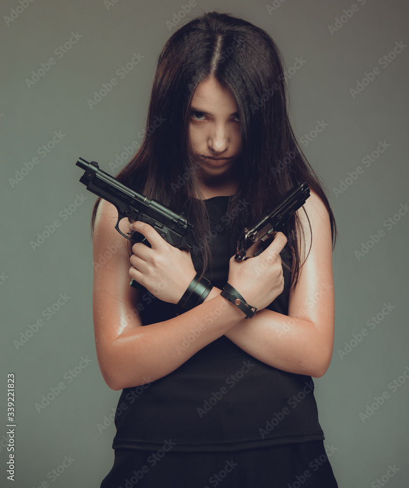 Shot of a sexy military woman posing with guns Shot of a sexy military woman posing with guns