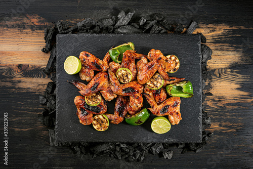 grilled chicken wings and vegetables on a stone dish