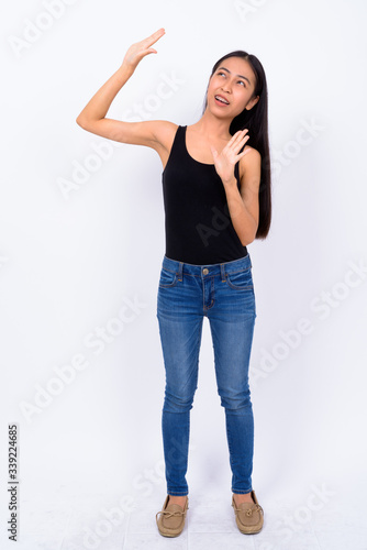Full body shot of stressed young Asian woman looking scared © Ranta Images
