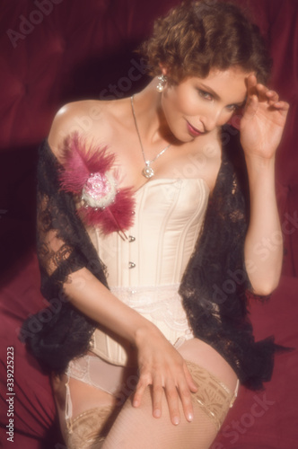 Vintage girl portrait in classic soft focus. Lies on a red sofa. Retro interior