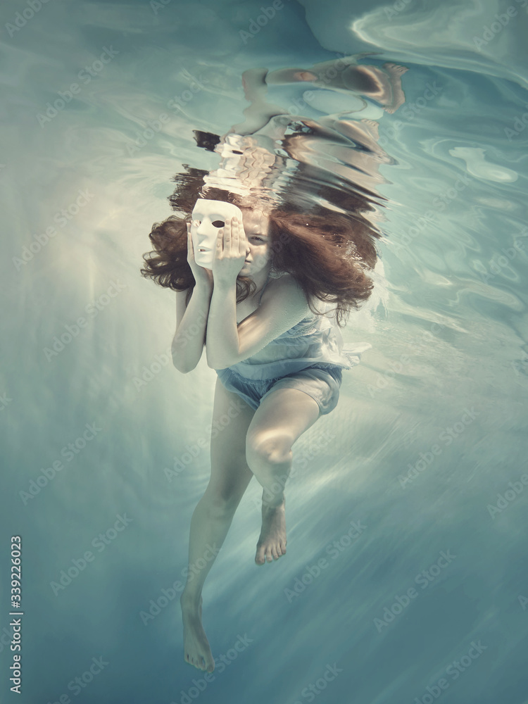 Portrait of a girl with a mask under water