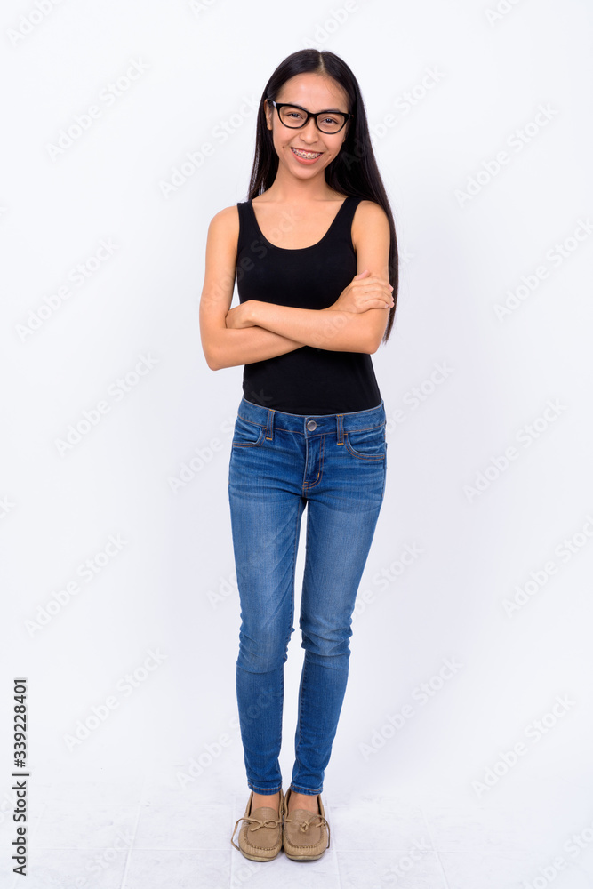 Full body shot of happy young Asian nerd woman smiling Full body shot of happy young Asian nerd woman smiling