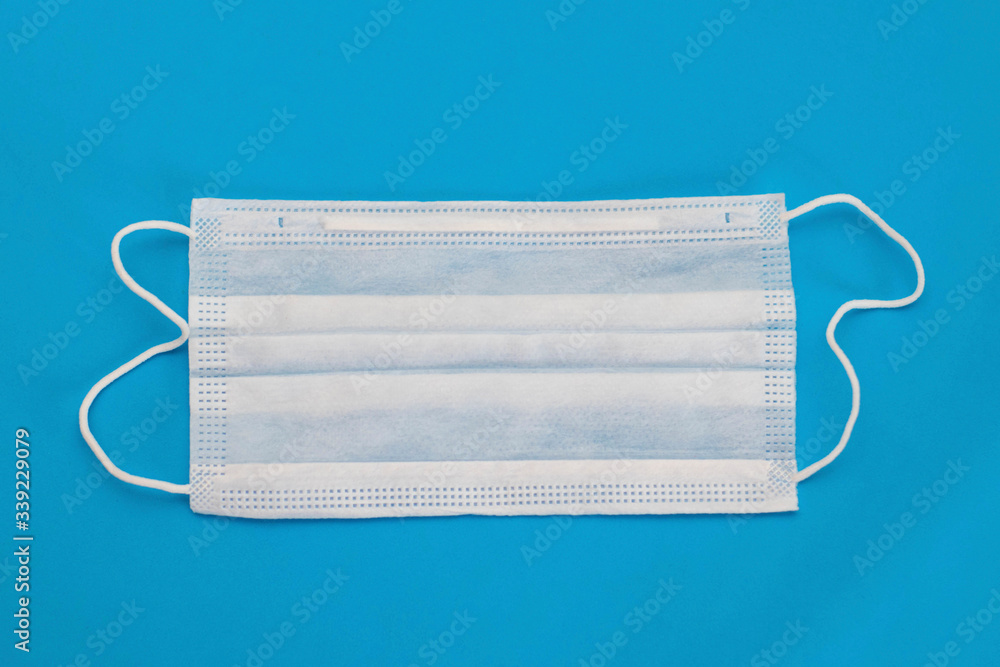 Protective medical mask on a blue background. Epidemic Prevention Protective medical mask on a blue background. Epidemic Prevention