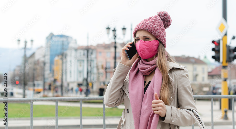 Fototapeta premium Woman with fashion mask using her phone