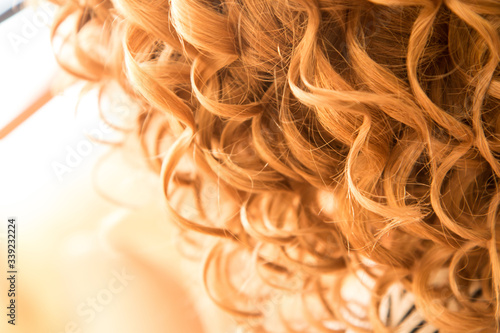 The detail of the curly hair of the woman. She is a bride and is prepared for the ceremonial. 