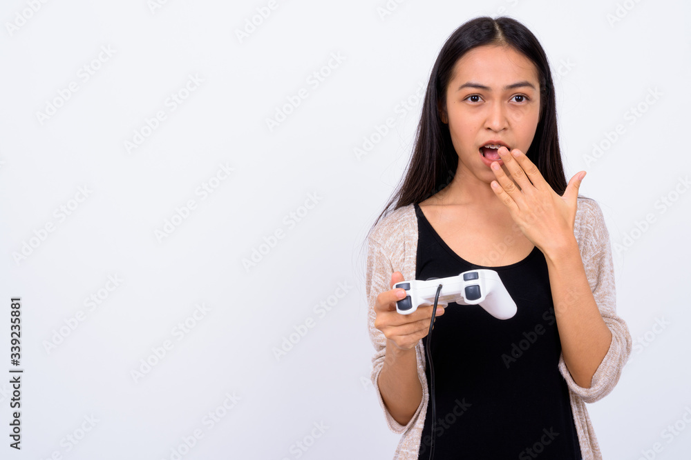 Portrait of young Asian woman playing games and looking shocked Portrait of young Asian woman playing games and looking shocked
