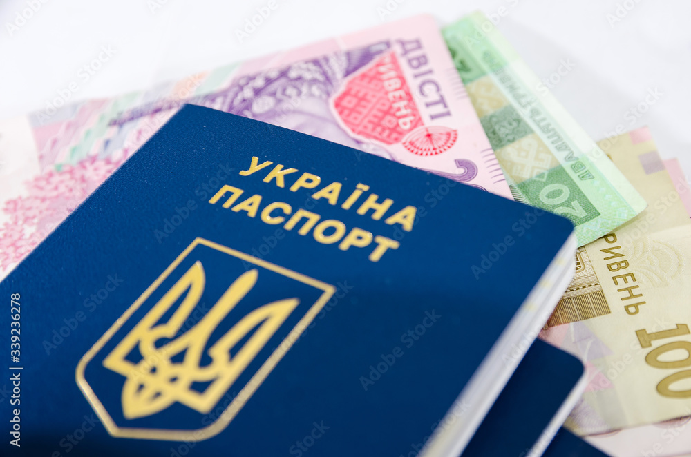 Ukrainian passport and hryvnia on white. Close-up. Ukrainian passport and hryvnia on white. Close-up.