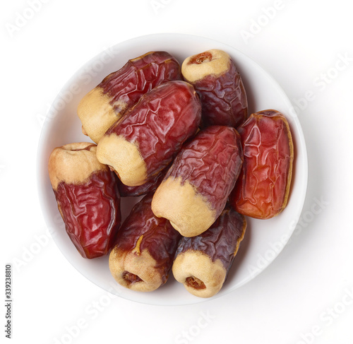 Bowl of dates isolated on white, from above