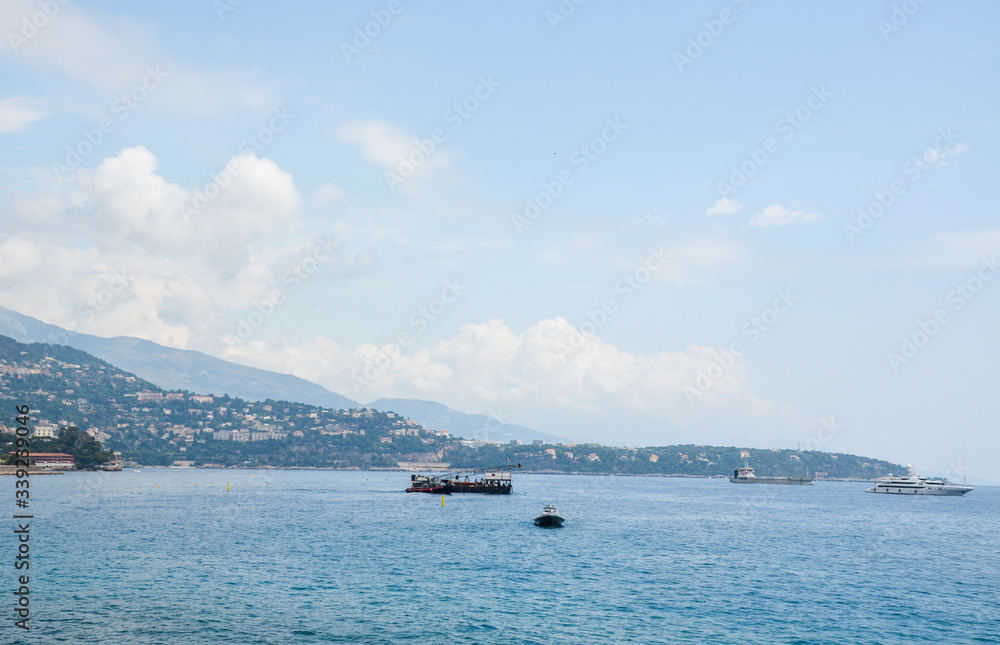 A famous view of Mediterranean coastline with ships, yachts and luxury residential apartment buildings in Monte Carlo Principality of Monaco A famous view of Mediterranean coastline with ships, yachts and luxury residential apartment buildings in Monte Carlo Principality of Monaco