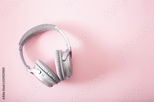 modern silver wireless headphones on pink background