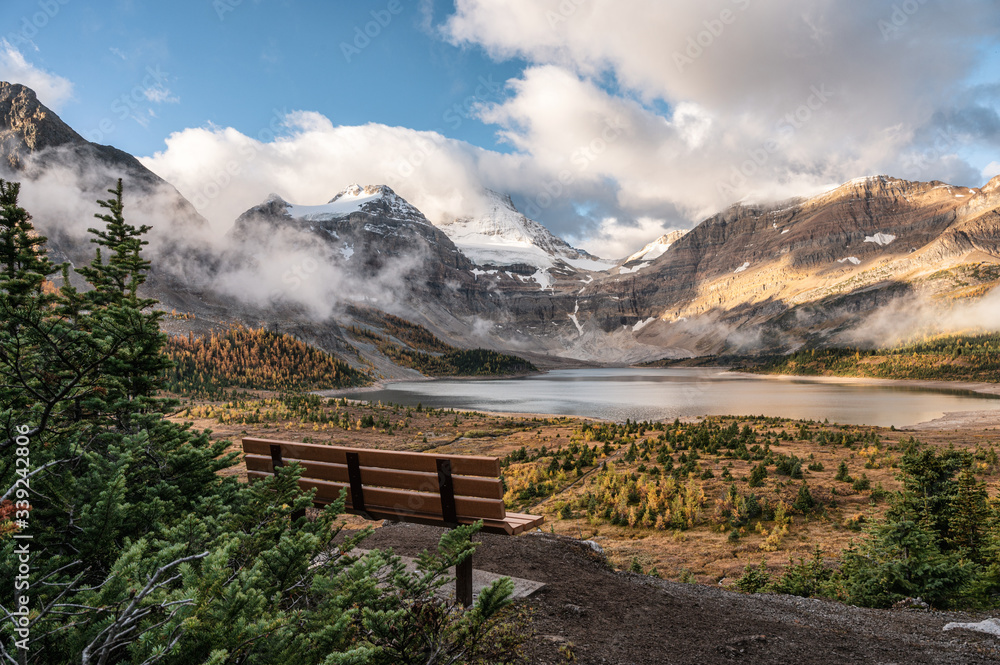 Wooden bench with mount Assiniboine and lake Magog in provincial park at British Columbia Wooden bench with mount Assiniboine and lake Magog in provincial park at British Columbia