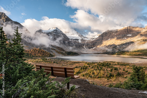 Wooden bench with mount Assiniboine and lake Magog in provincial park at British Columbia