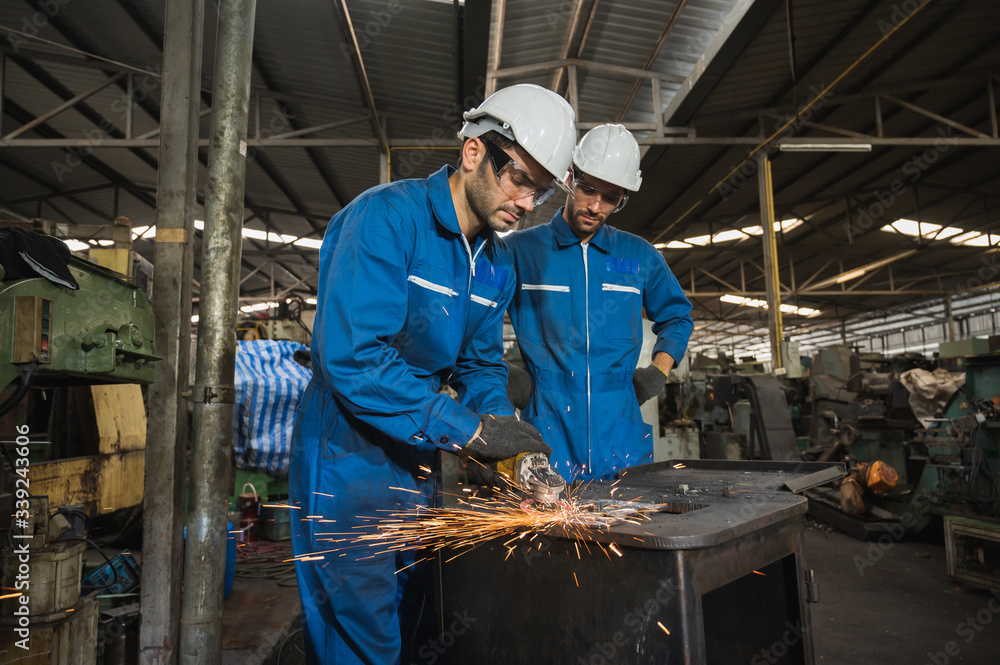 Industrial worker cutting metal and steel with many sparks