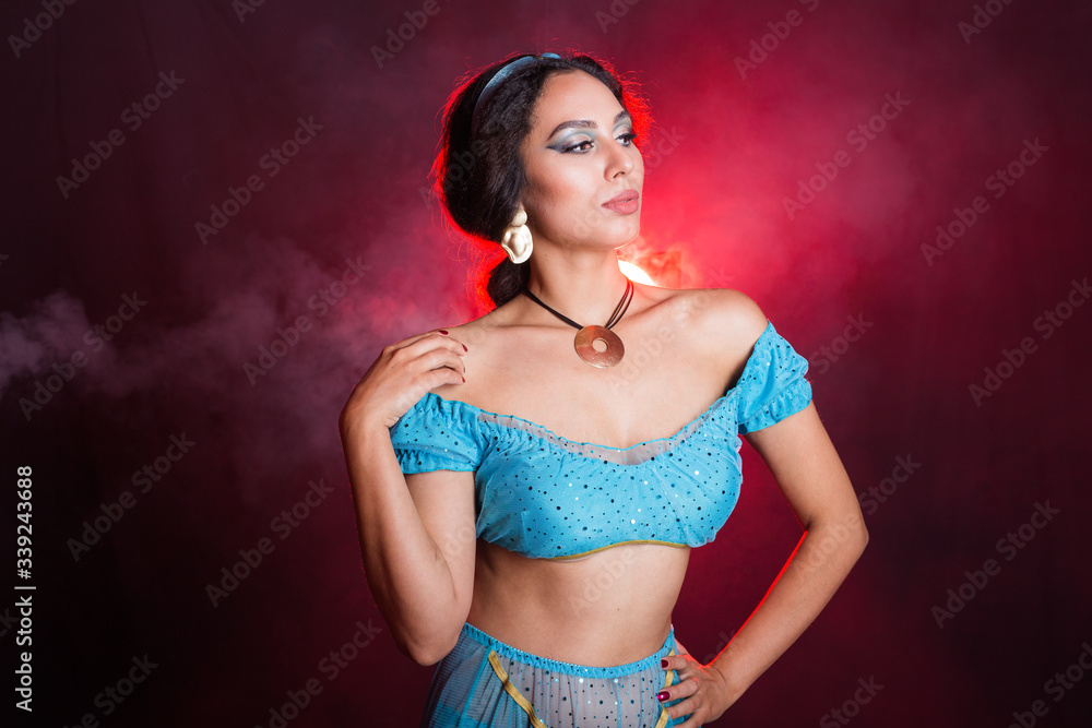 Obraz premium Magic, cosplay, carnival and fairy tale concept - Portrait of a young woman in the image of an Eastern fairy Princess on dark background.