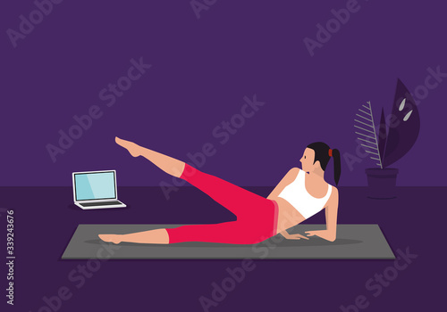 Home fitness workout class live streaming online. Woman doing training cardio aerobic exercises watching videos on a laptop in the living room at home.