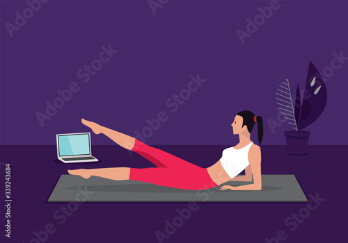Home fitness workout class live streaming online. Woman doing training cardio aerobic exercises watching videos on a laptop in the living room at home.