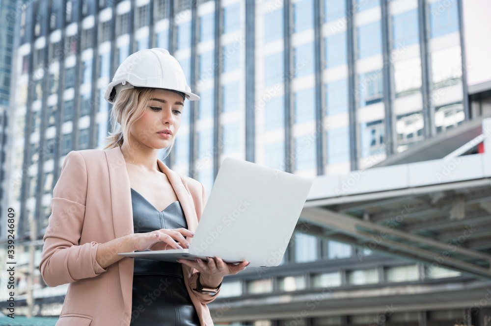 Portrait of pretty young civil engineer woman working planning project with laptop on construction building background. Evolution construction concept. Portrait of pretty young civil engineer woman working planning project with laptop on construction building background. Evolution construction concept.