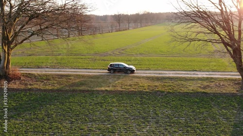 Schwarzes Auto SUV auf Feldweg voller Staub beim Sonnenuntergang während der Corona Pandemie