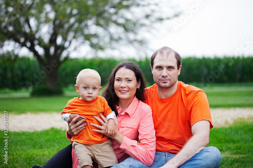 Portrait of happy family with little son outdoors