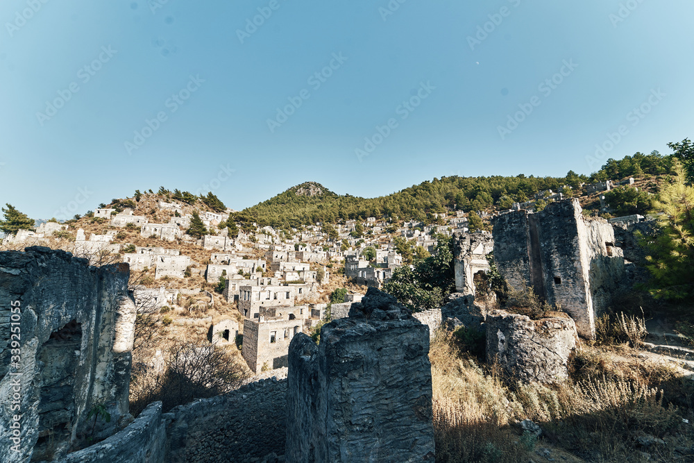 The abandoned Greek village of Kayakoy, Fethiye, Turkey. Ghost Town Kayakoy. Turkey, evening sun. Ancient abandoned buildings of rock and stone.