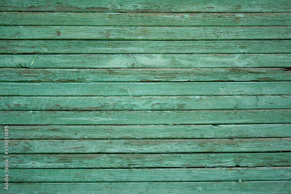 Obraz premium Wooden fence painted in green, peeling cracked paint