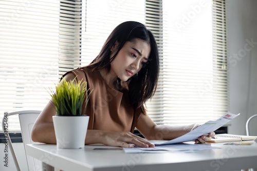 Young Asian woman is stressed and overthink by debt from many credit cards and bills. photo