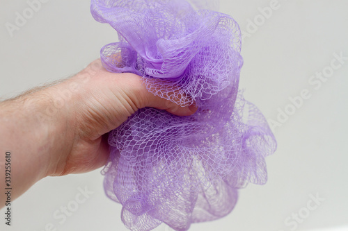 Fotografi hand holds a purple washcloth for a shower