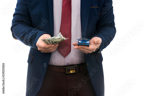 businessman hold toy car and us money for sale or rent car isolated on white.