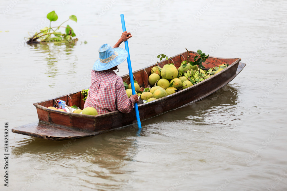 Obraz premium The vendors paddle on the river to sell fruits to tourists.