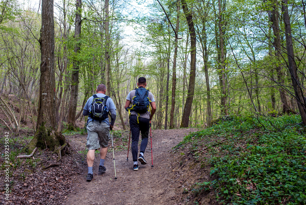Two men with backpack hiking and enjoying the day in mountains Two men with backpack hiking and enjoying the day in mountains