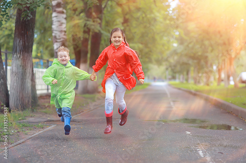 children run in the yellow autumn park rain / fun walk autumn seasonal landscape weather wet