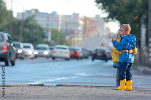 children cross the road / boy and girl small children in the city at the crossroads, car, transport