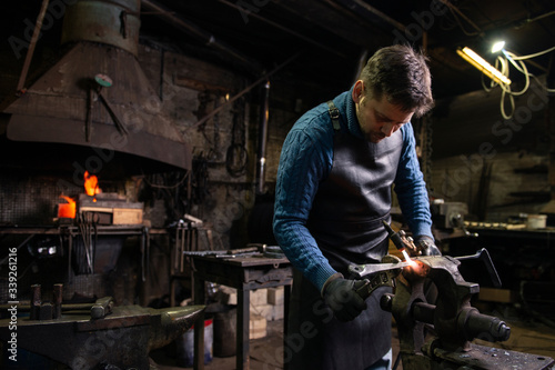 Blacksmith working with metal in his workshop