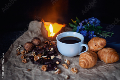 coffee, croissants, flowers craft paper, chocolate with nuts, walnuts candle