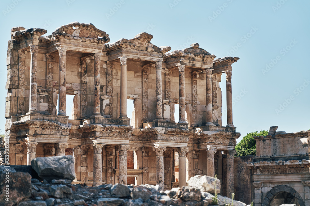 Obraz premium The ruins of Celsus Library in Ephesus at sunny evening sun. Beautiful light of the old ancient rocks and stones, turkey