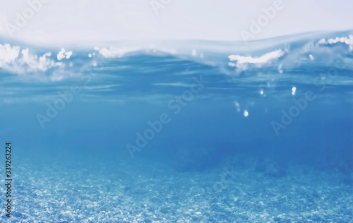 Unfocused underwater split view of Greek sea with pebbles