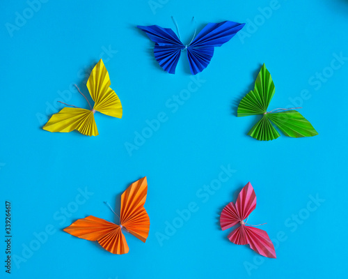 Origami multicolored butterflies on a blue background © Larisa