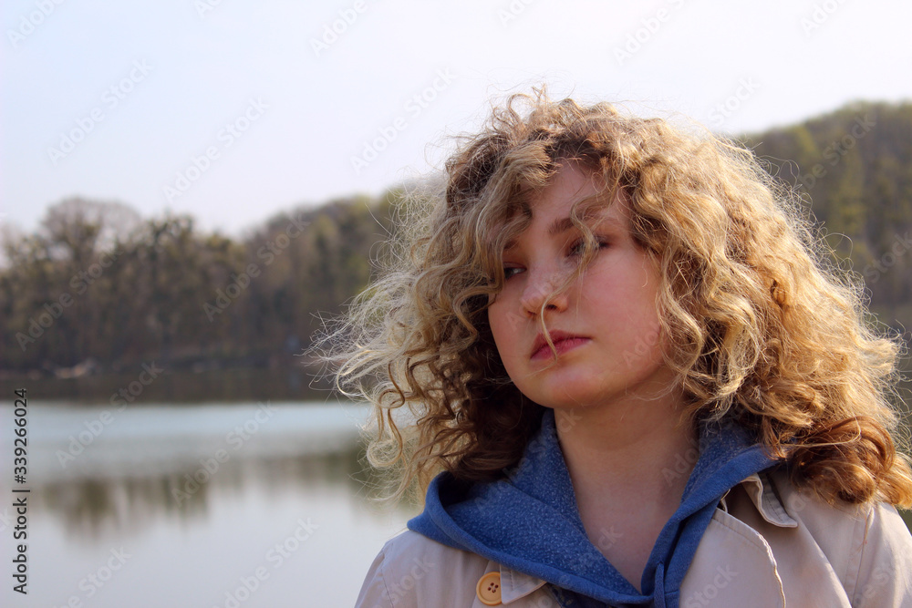 Close up portrait of a young girl outdoor. People, travel, nature concept. Close up portrait of curly girl.