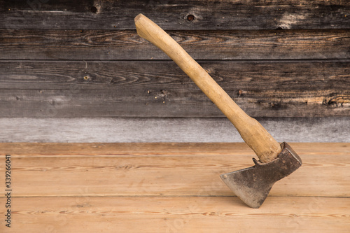 Old ax with a wooden handle stuck in wooden log. Concept for woodworking or deforestation. Selective focus. photo