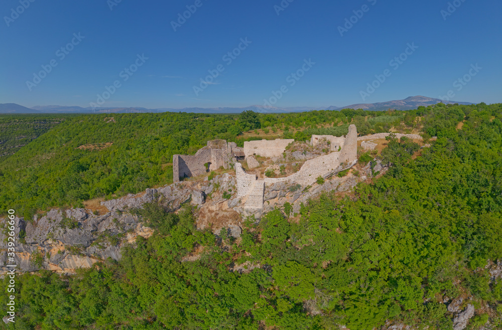 Drone aerial view of the archaeological remains of the medieval fort Necven, located on the west side of mountain Promina on top of the canyon of the river Krka in Dalmatian Zagora in Croatia.