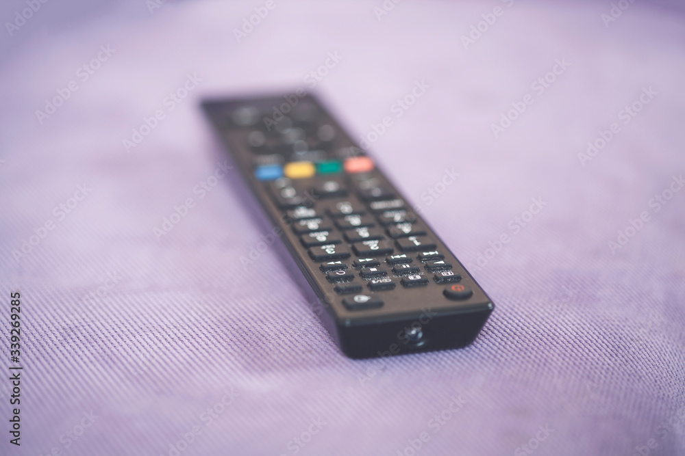 TV remote control on couch indoors, closeup TV remote control on couch indoors, closeup