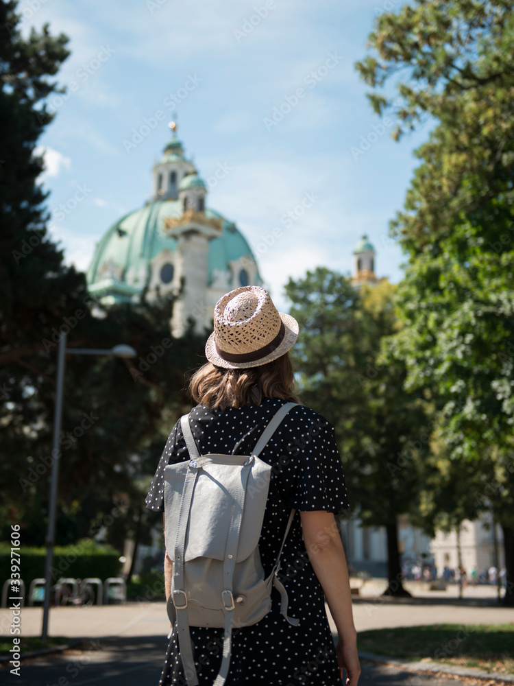 Obraz premium Young female tourist standing on street and enjoying the view of beautiful architectural landmark