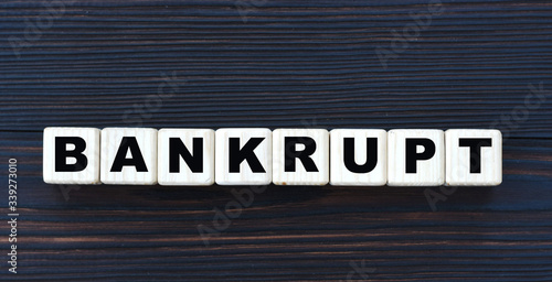 concept word BANKRUPT on cubes on a beautiful dark wooden background