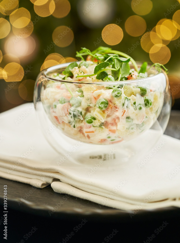 Salad 'Olivier' (famous chicken salad from Russia) served in a glass round bowl Salad 'Olivier' (famous chicken salad from Russia) served in a glass round bowl
