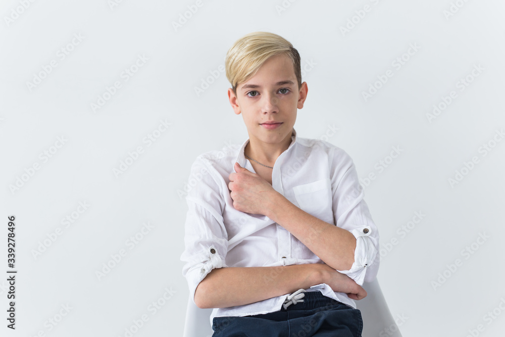 Solitude, loneliness and boredom concept - Bored teen student sitting in a school chair isolated on white background Solitude, loneliness and boredom concept - Bored teen student sitting in a school chair isolated on white background