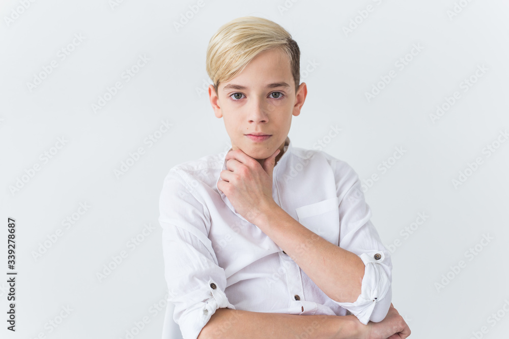 Solitude, loneliness and boredom concept - Bored teen student sitting in a school chair isolated on white background Solitude, loneliness and boredom concept - Bored teen student sitting in a school chair isolated on white background