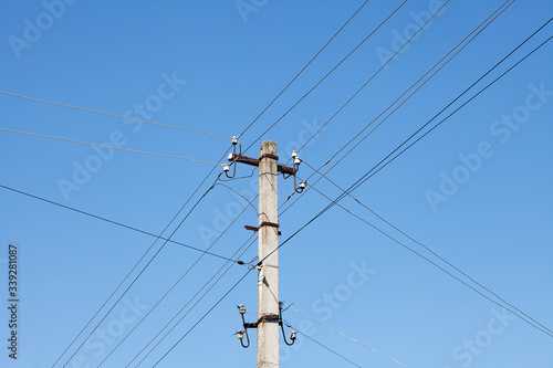 Electric pole with electric wires on blue sky