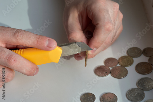 A man counts money and divides it. Round coins. Cutting of money with a knife